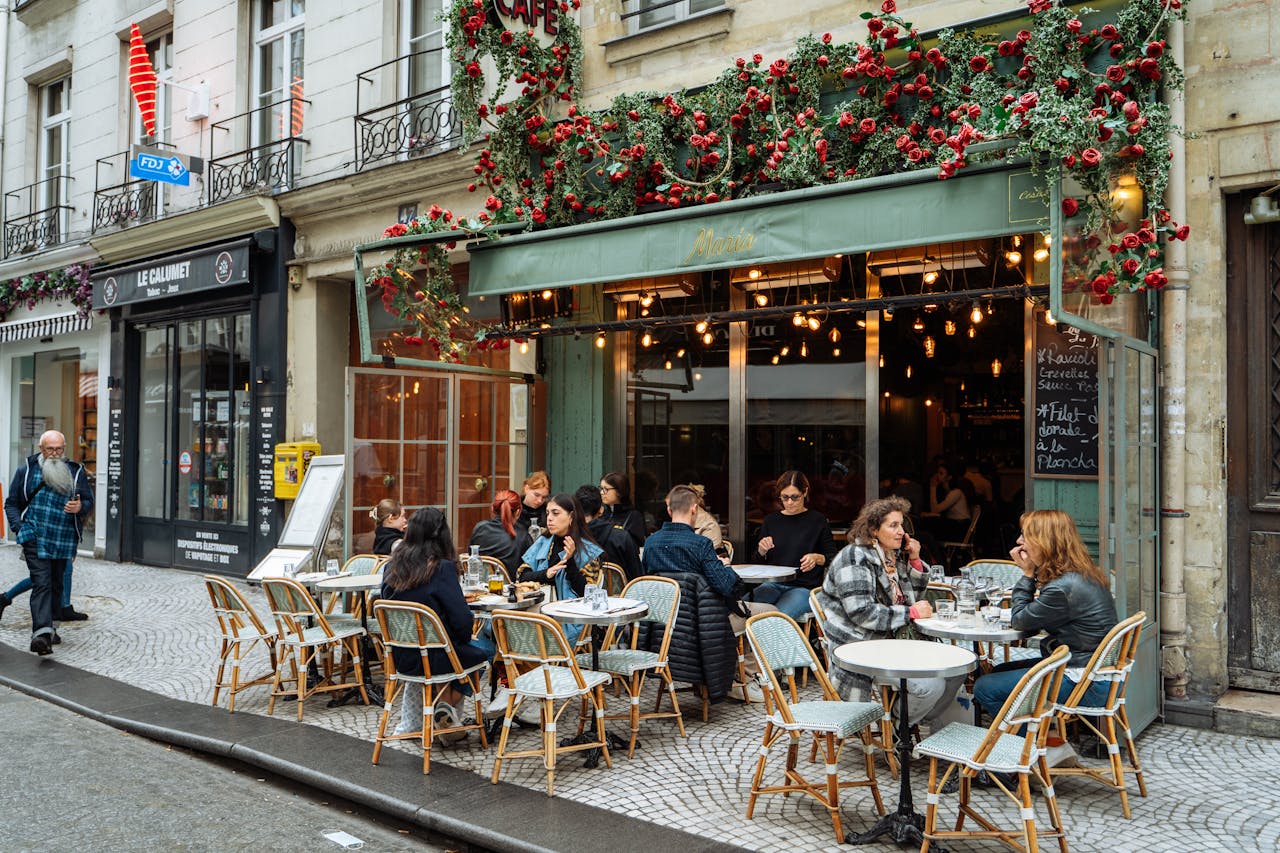 services-01 A lively street scene of a Parisian cafe with vibrant outdoor ambiance and dining.